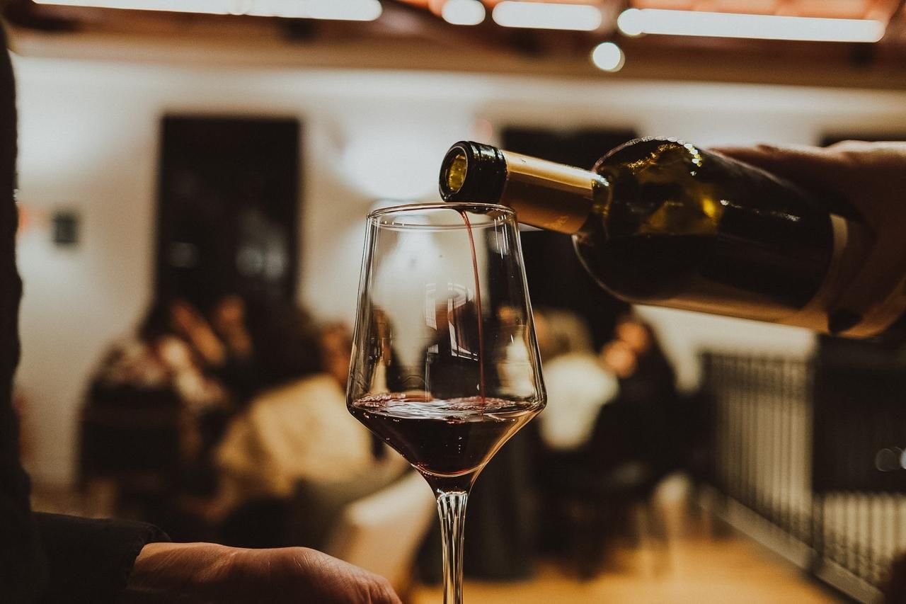 Taça sendo servida com vinho tinto durante a Experiência Cliente Mais Black em vinhedos gauchos