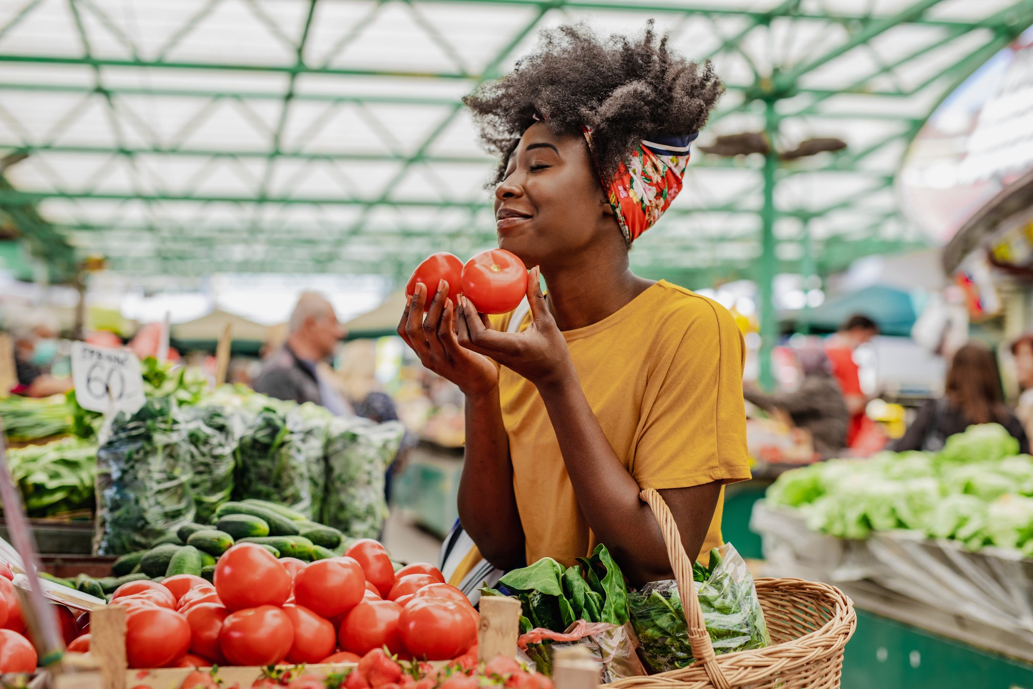 Mulher segurando tomates em um mercado