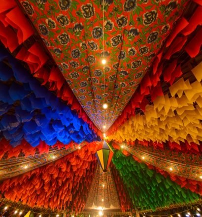 Decoração colorida de Festa Junina com bandeirinhas e lanternas.