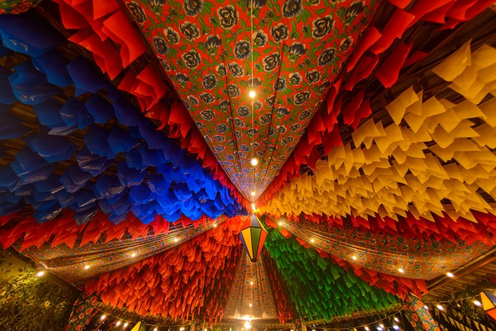 Decoração colorida de Festa Junina com bandeirinhas e lanternas.