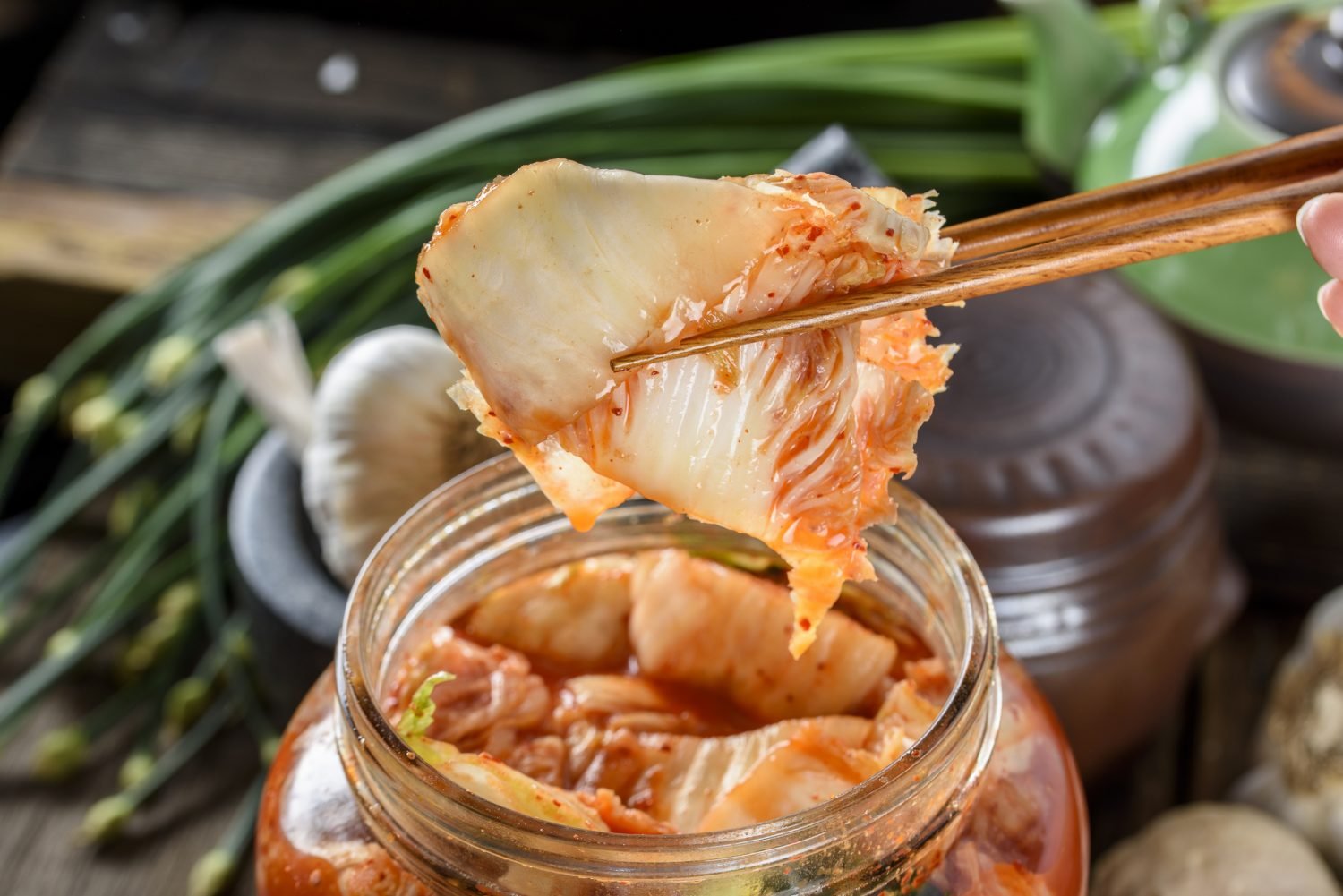 Kimchi sendo retirado de um pote com hashi