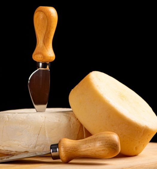 Queijos meia cura com faca de queijo.