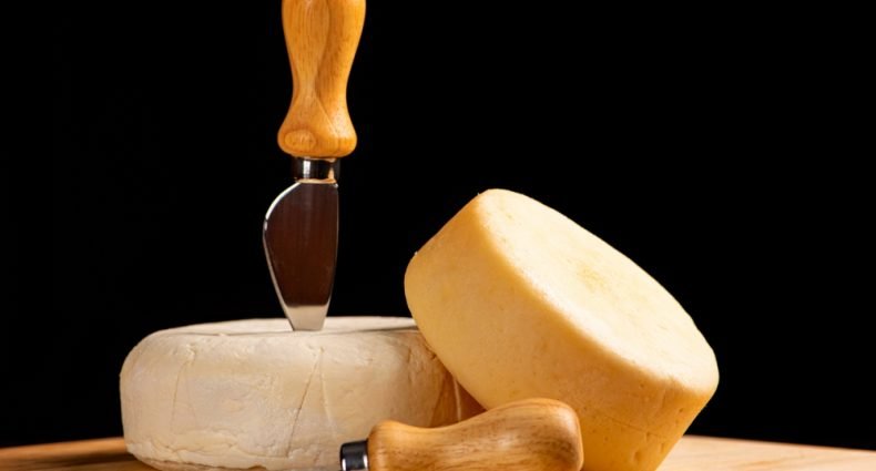 Queijos meia cura com faca de queijo.