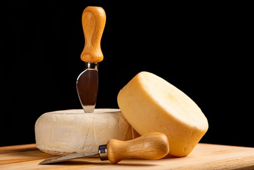 Queijos meia cura com faca de queijo.