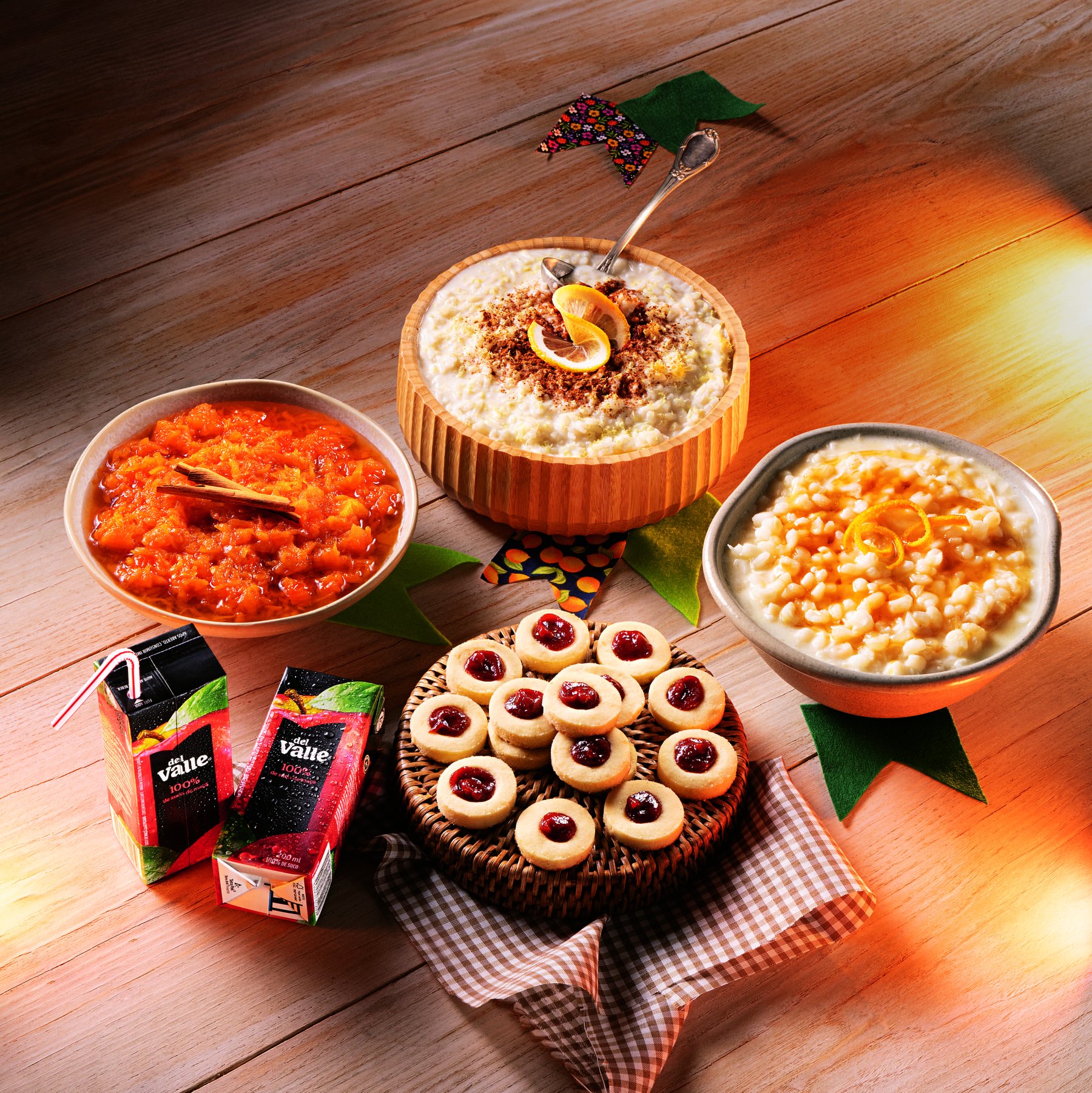 Variedade de sobremesas típicas da Festa Junina, incluindo canjica e biscoitos, com bebidas ao lado.