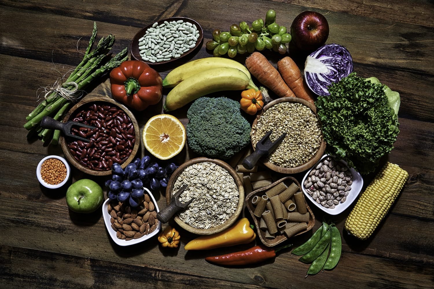 Variados alimentos ricos em fibras, incluindo frutas, verduras e grãos.