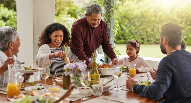 Família reunida em uma mesa decorada, celebrando o Dia dos Pais.