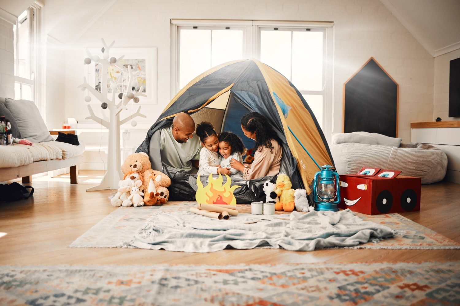 Família desfrutando de férias em casa, com crianças brincando em uma barraca.