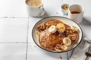 Panquecas de banana com acompanhamentos saudáveis.