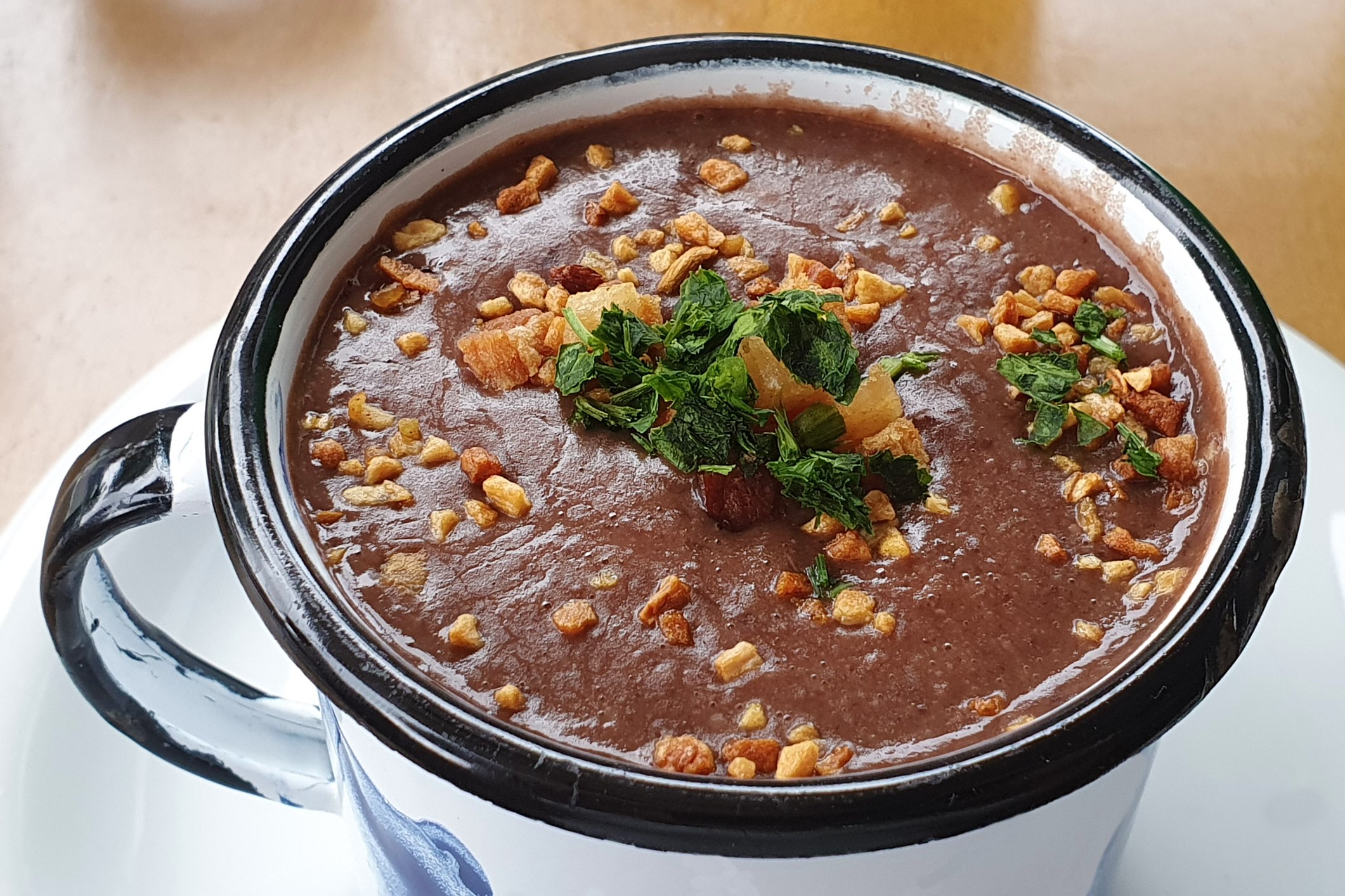 Sopa de feijão armazenada em um recipiente com cobertura.