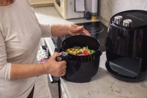 Espetinho de legumes sendo inserido na Airfryer.