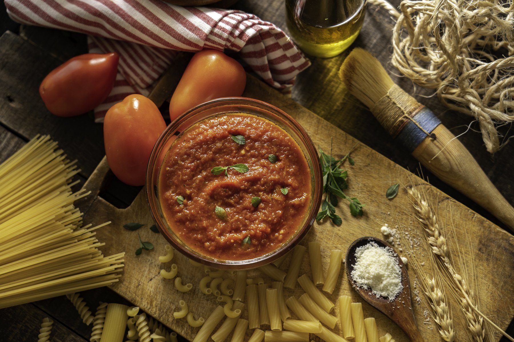 Molho de tomate com macarrão e ingredientes que foram usados para o preparo do molho.