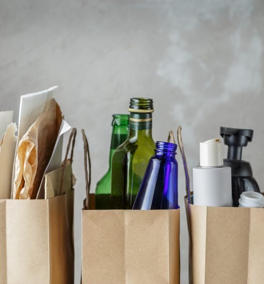 Sacos de papel contendo lixo reciclável, incluindo vidro e plásticos.