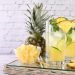 Caipirinha de abacaxi com fatias e cubos de abacaxi em copos altos