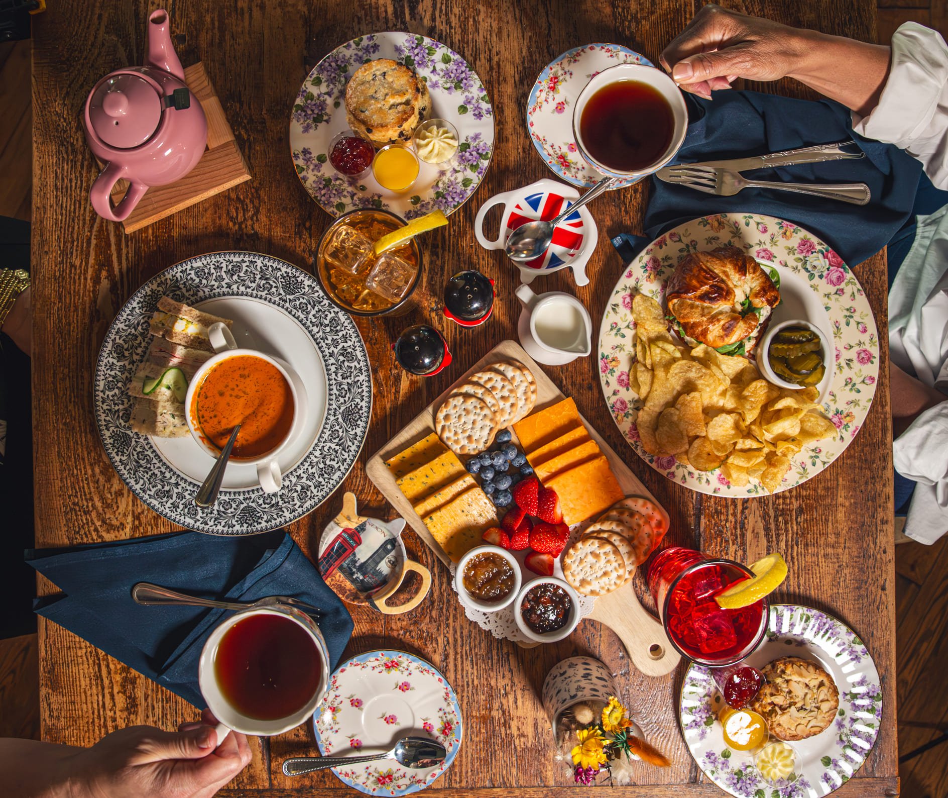 Mesa completa de chá da tarde com bolos, queijos e frutas