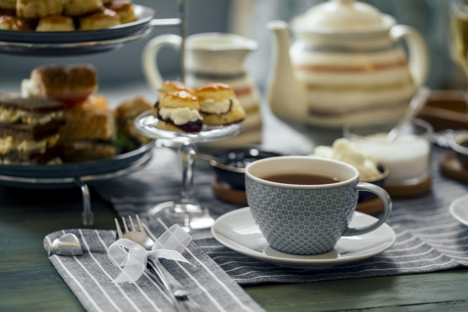 Xícara de chá elegante com petiscos em mesa posta para chá da tarde