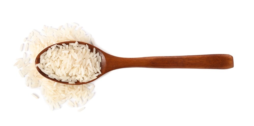Colher de madeira cheia de arroz cru