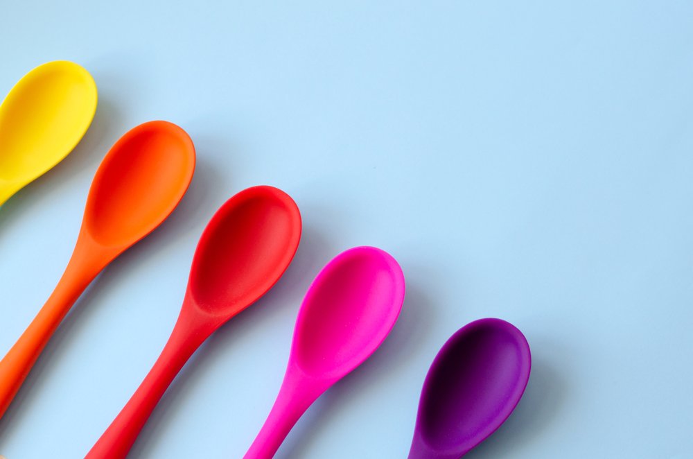 Colheres de silicone coloridas sobre fundo azul