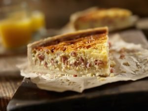 Quiche deliciosa cortada ao meio, destacando seu recheio cremoso.