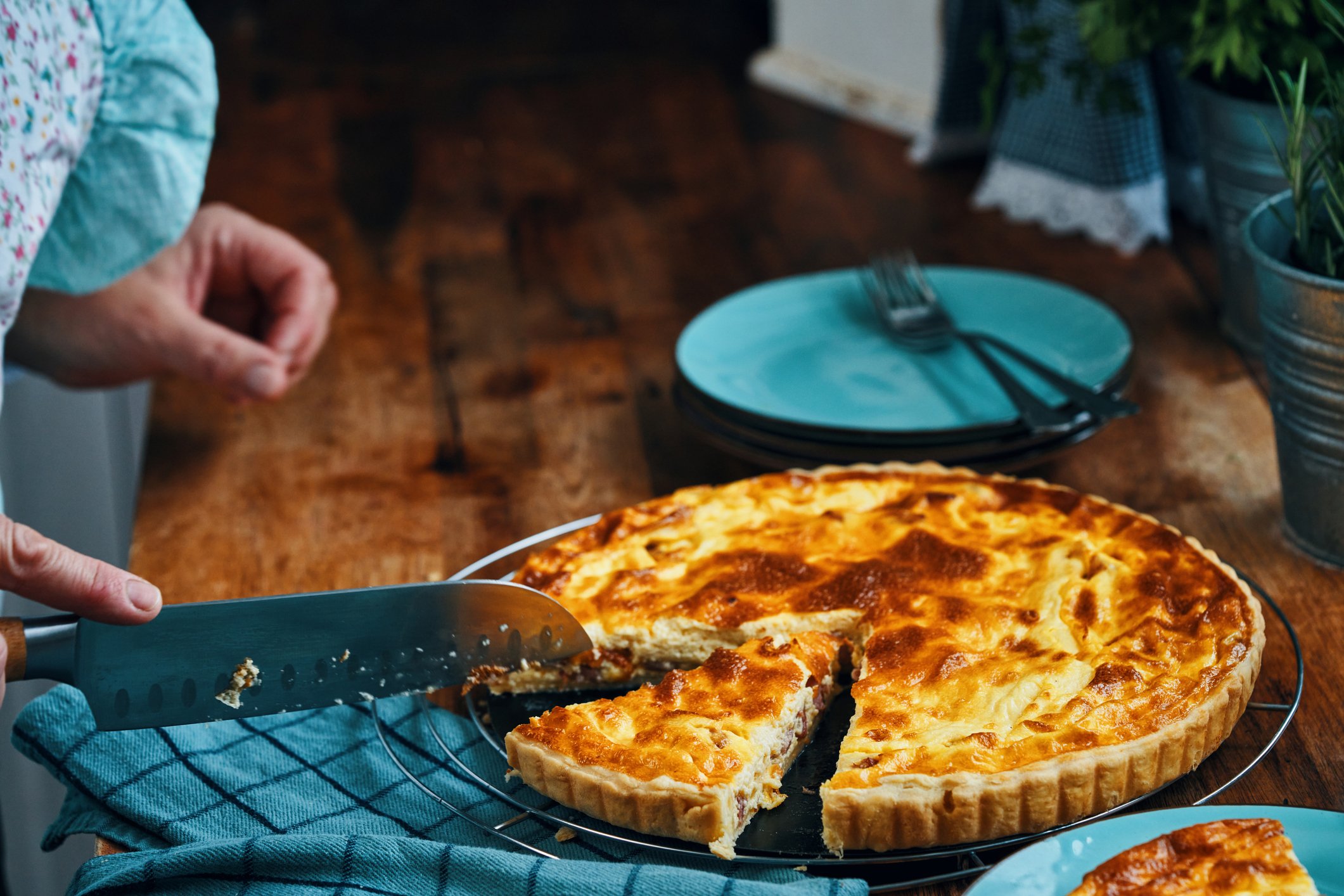 Preparação da Quiche Lorraine, com ingredientes frescos ao fundo.