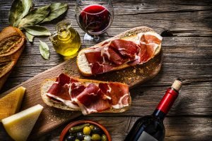 Presunto parma em pão italiano acompanhado de vinho tinto