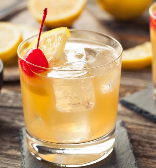 Variação colorida de Whisky Sour em um copo decorado.