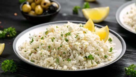 Prato de arroz à grega com limão e azeitonas em prato branco