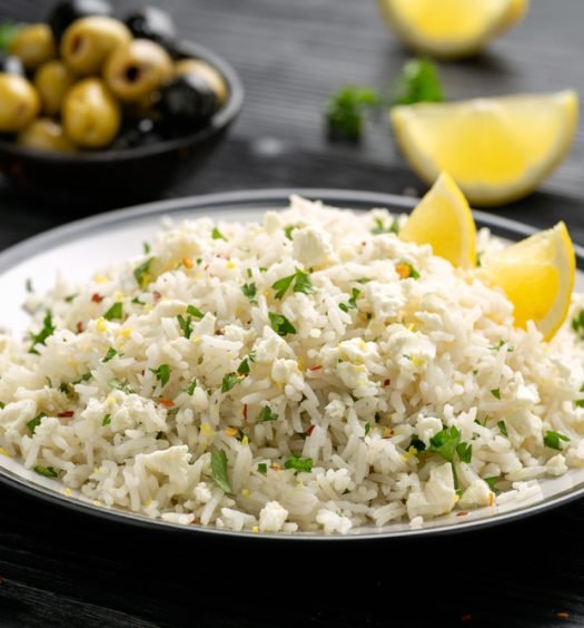 Prato de arroz à grega com limão e azeitonas em prato branco