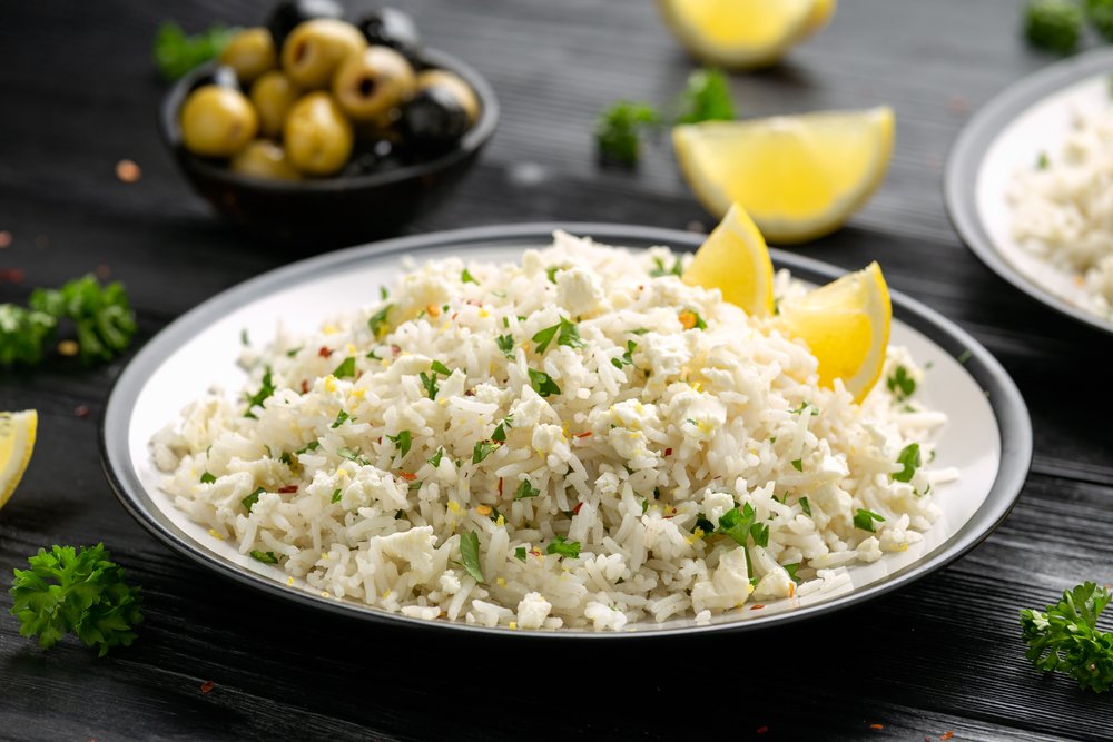 Prato de arroz à grega com limão e azeitonas em prato branco