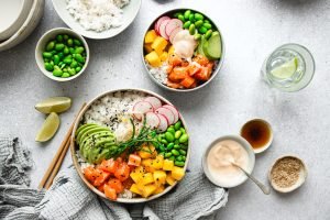 Bowl com arroz, edamame, abacate, manga e salmão — refeição equilibrada e colorida