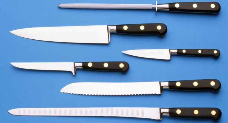 Conjunto de facas de cozinha e chaira sobre fundo azul mostrando diferentes tipos de lâminas