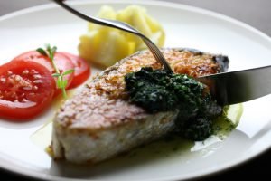 Corte de filé de peixe Belle Meunière com molho verde e acompanhamento de tomate
