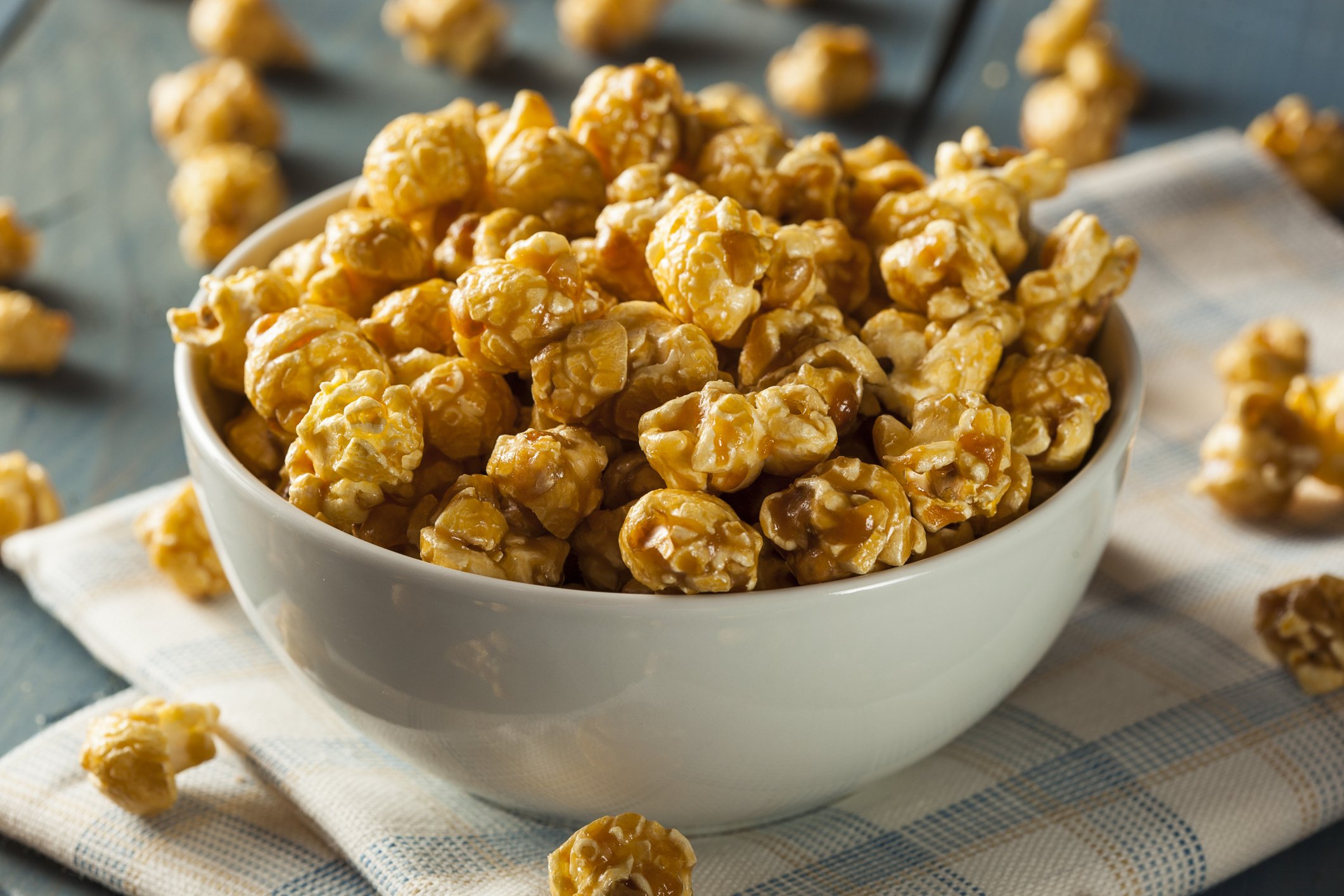 Tigela branca cheia de pipoca caramelizada dourada e crocante, perfeita para um lanche doce ou sessão de cinema em família.