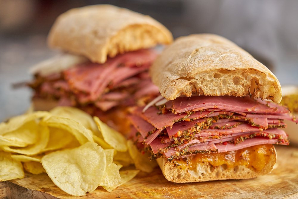 Sanduíches de pastrami clássicos com muitas fatias e batatas chips, perfeitos para um lanche saboroso
