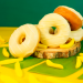 Donuts amarelos decorativos sobre fundo verde do Pão de Açúcar com recheios Fini Clássicos