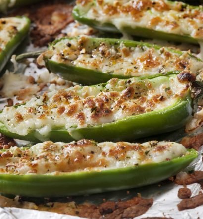 Pimentões verdes recheados com carne moída e queijo derretido assados em papel alumínio