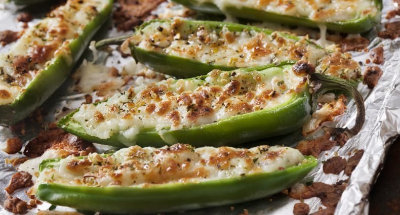 Pimentões verdes recheados com carne moída e queijo derretido assados em papel alumínio
