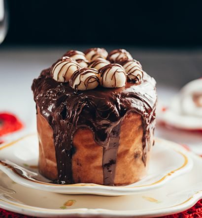 chocotone de natal com cobertura de chocolate e marshmallows servido em prato branco para ceia de natal simples e deliciosa