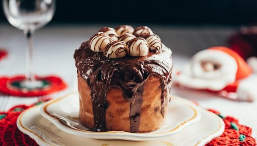 chocotone de natal com cobertura de chocolate e marshmallows servido em prato branco para ceia de natal simples e deliciosa