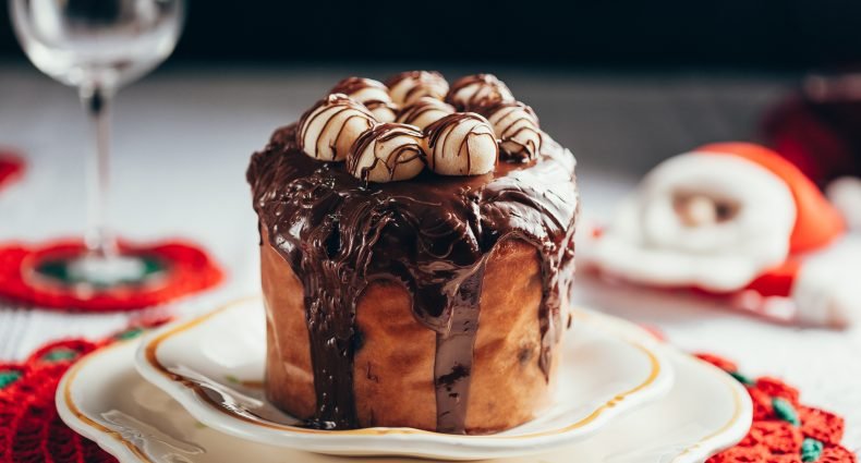 chocotone de natal com cobertura de chocolate e marshmallows servido em prato branco para ceia de natal simples e deliciosa