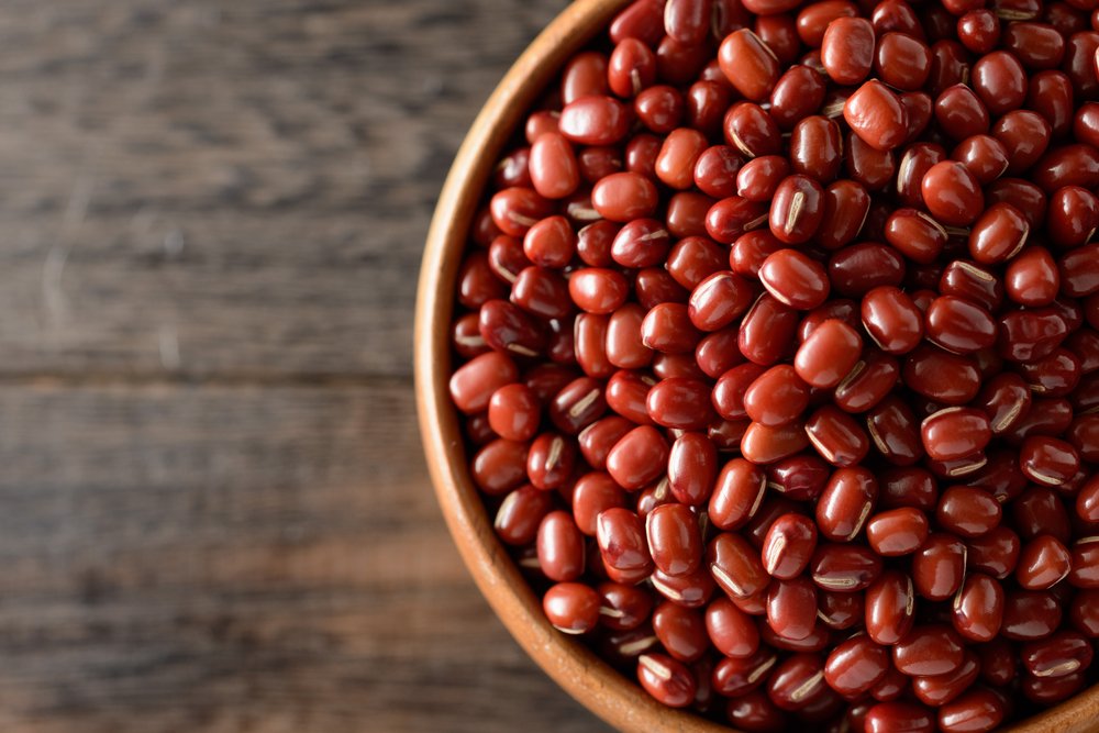 Feijão-azuki em close, grão vermelho em tigela sobre mesa de madeira – tipo de feijão entre os 11 grãos mais consumidos